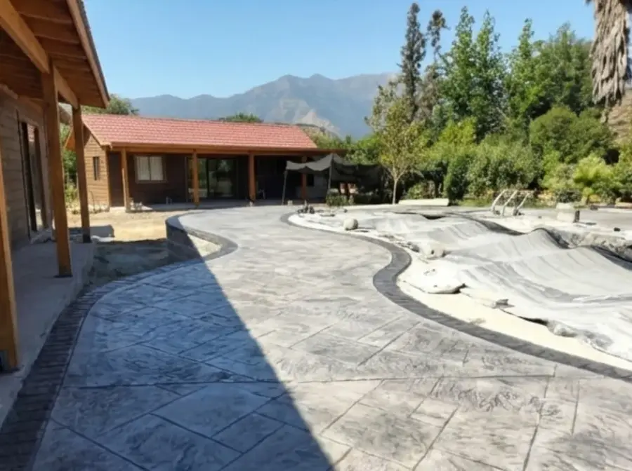 Terraza de hormigón estampado gris con borde, con la cordillera de fondo